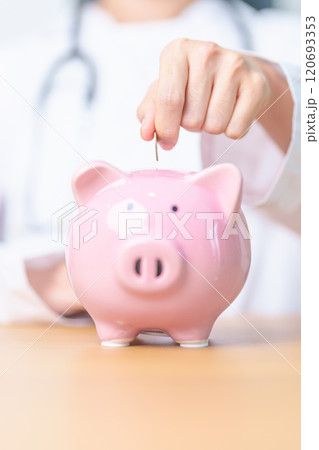 Doctor holding piggy bank and putting coin. and Healthcare cost, Money Saving, Health Insurance, Medical, Donation and Financial concepts 120693353