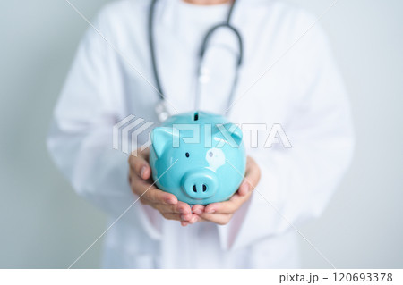 Doctor holding piggy bank and putting coin. and Healthcare cost, Money Saving, Health Insurance, Medical, Donation and Financial concepts 120693378