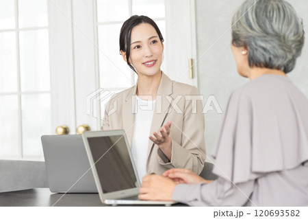 シニア女性に説明をするビジネスウーマン 120693582
