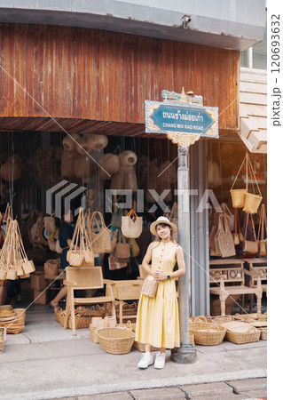 Young asian woman traveler in dress with hat traveling to wicker shop on Chang Moi Kao Road, Tourist visit at the old city in Chang Mai, Thailand. Asia Travel, Vacation and summer holiday concept 120693632