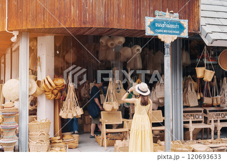 Young asian woman traveler in dress with hat traveling to wicker shop on Chang Moi Kao Road, Tourist visit at the old city in Chang Mai, Thailand. Asia Travel, Vacation and summer holiday concept 120693633