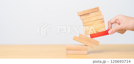 woman hand pulling wood domino blocks on table. Crisis, fall Business, Risk management, Economic recession, Strategy and solutions concept 120693714