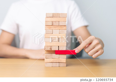 hand pulling wooden block tower on table. Business planning, Risk Management, Solution, leader, strategy, Crisis, falling Business, and Economic recession concept 120693734