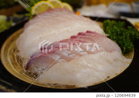 Raw fish sashimi on a plate with lemon and parsley 120694639
