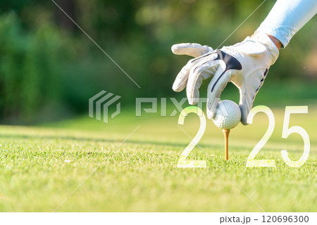 Close up hand Golfer woman putting golf ball for Happy New Year 2025 on the green golf for new healthy.  120696300