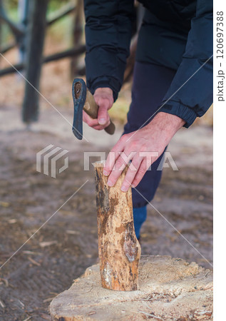 Chopping wood for the fire with an axe. A man's hand with an axe chopping wood. High quality photo Chopping wood for the fire with an axe. A man's hand with an axe chopping wood. High quality photo 120697388