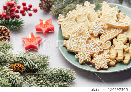 Christmas cookies decorated with icing celebrating christmas eve with candles and pine branches Christmas cookies decorated with icing celebrating christmas eve with candles and pine branches 120697566