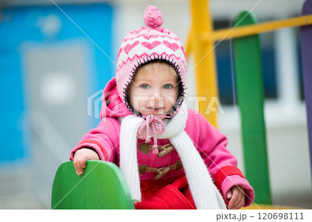 Baby girl playing on winter playground 120698111