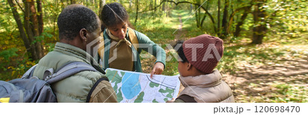 Website banner with high angle shot of African American teenage girl pointing at map while her family reading map Website banner with high angle shot of African American teenage girl pointing at map while her family reading map 120698470