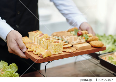 Serving Assorted Appetizers on a Wooden Tray at Event 120699307