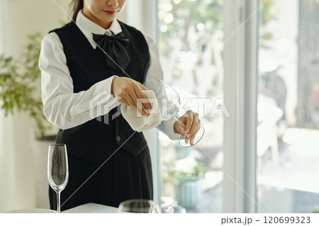 Cleaning Wine Glass in Elegant Dining Setting 120699323