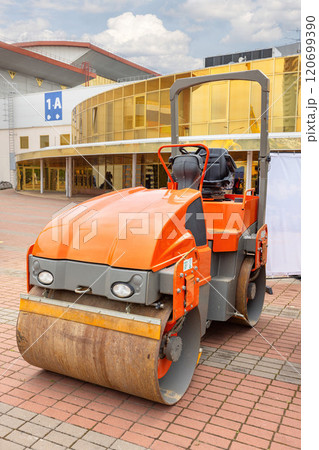Heavy machinery smoothing pavement at a construction site near an architectural landmark Heavy machinery smoothing pavement at a construction site near an architectural landmark 120699390