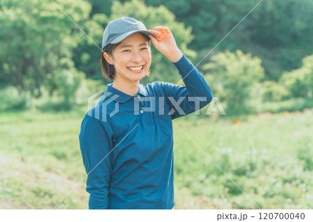 青いポロシャツと青いキャップ姿の働く女性 青いポロシャツと青いキャップ姿の働く女性 120700040