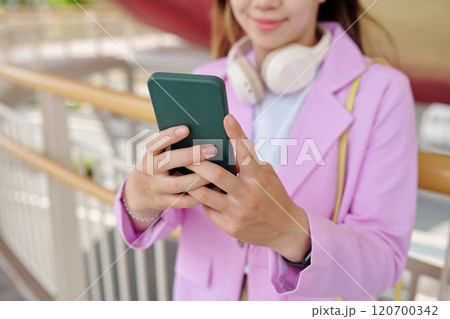 Smiling Woman Using Smartphone While Standing Outdoors Smiling Woman Using Smartphone While Standing Outdoors 120700342