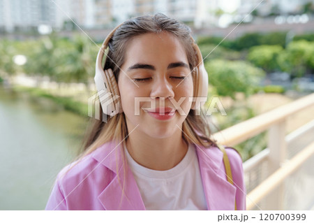 Enjoying Music on a Sunny Day Wearing Headphones 120700399