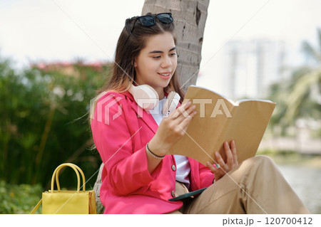 Reading Book Under Tree in Outdoor Setting 120700412