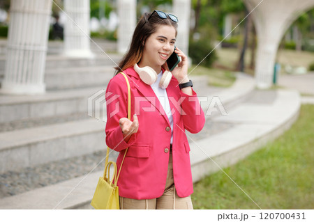 Talking on Phone While Wearing Bright Pink Blazer 120700431