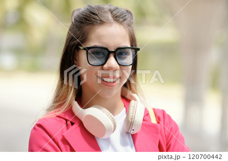 Portrait of Smiling Woman Wearing Pink Jacket and Headphones 120700442