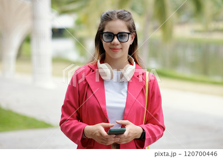 Smiling Woman Wearing Sunglasses and Holding Smartphone Smiling Woman Wearing Sunglasses and Holding Smartphone 120700446