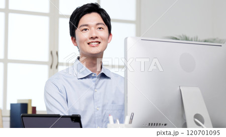 作業中に笑顔で対応するビジネスマン 作業中に笑顔で対応するビジネスマン 120701095
