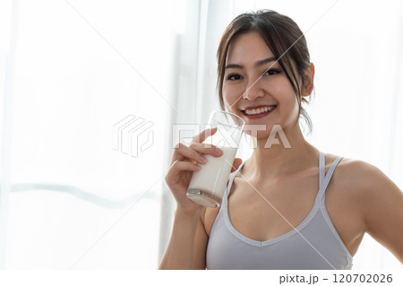 Asian beautiful attractive female sportswear holding glass drinking milk food nutrition healthy with active exercise. contains good fats, which give energy to body. Milk high calcium. Asian beautiful attractive female sportswear holding glass drinking milk food nutrition healthy with active exercise. contains good fats, which give energy to body. Milk high calcium. 120702026