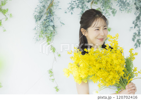 ミモザの花束を持つ若い女性 ミモザの花束を持つ若い女性 120702416
