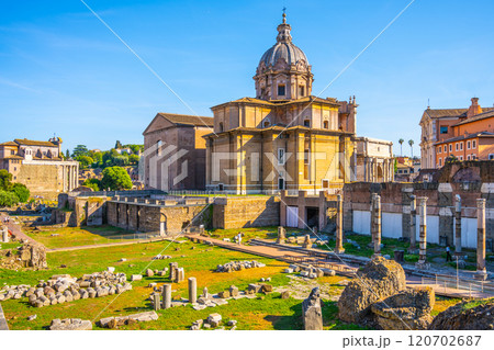 The Santi Luca e Martina church stands majestically between the Roman Forum and Forum of Caesar, showcasing its architectural beauty under a clear blue sky during a sunny day in Rome. The Santi Luca e Martina church stands majestically between the Roman Forum and Forum of Caesar, showcasing its architectural beauty under a clear blue sky during a sunny day in Rome. 120702687