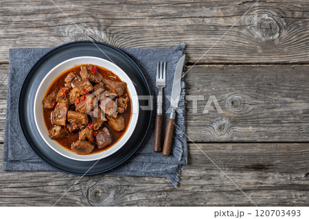 beef stew in a white bowl on rustic wooden table beef stew in a white bowl on rustic wooden table 120703493