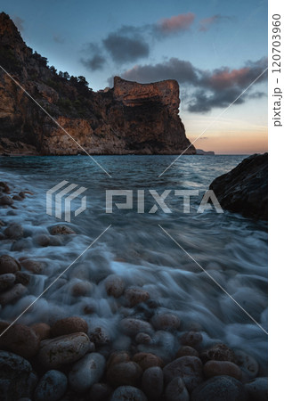 The rock rises above the blue sea at sunset or sunrise The rock rises above the blue sea at sunset or sunrise 120703960
