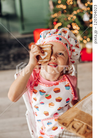 a girl child in the kitchen with a Christmas tree 120704023
