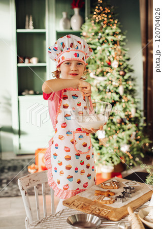 a girl child in the kitchen with a Christmas tree 120704026
