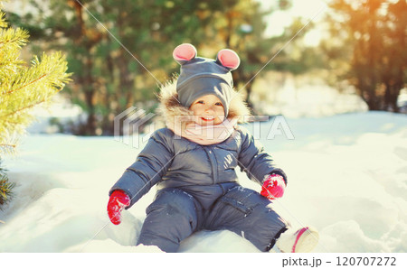 Winter happy smiling child playing in snow at sunny warm day 120707272