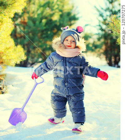 Winter little child playing with shovel toy in snow Winter little child playing with shovel toy in snow 120707275