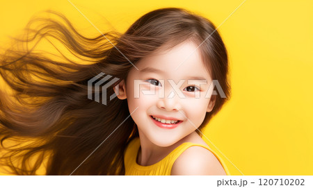 Portrait of smiling asian girl child with long white hair creamy yellow background. 120710202