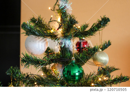 New Year's balls with garland on the top of the tree in the apartment New Year's balls with garland on the top of the tree in the apartment 120710505