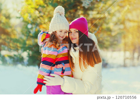 Winter happy smiling mother and child over snowy sunny background 120710556