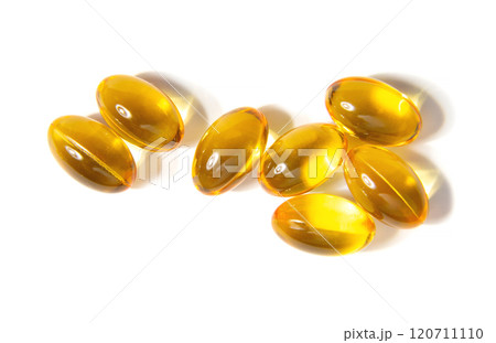 Golden Gelatin Capsules Arranged on a Clean White Surface Showcasing Their Smooth Texture Golden Gelatin Capsules Arranged on a Clean White Surface Showcasing Their Smooth Texture 120711110