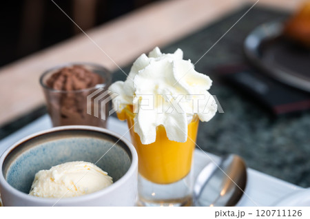 Coffee served with sweet dessets like a cake, vanilla ice scoop and custard in Belgium 120711126