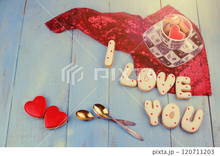 Homemade cookies in the form of a heart or I love you words on Valentine's Day on a blue board top view 120711203
