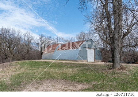 Rustic Quonset in Serene Countryside with Clear Blue Sky and Surrounding Trees. 120711710
