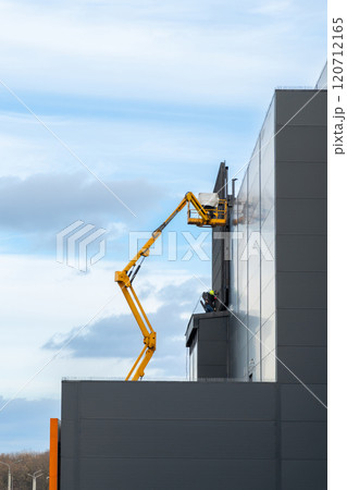 Two workers in hard hats mount elements of outdoor video advertising Two workers in hard hats mount elements of outdoor video advertising 120712165