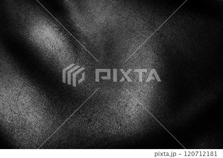 Close-up of textured black fabric highlighting soft curves and light reflections 120712181