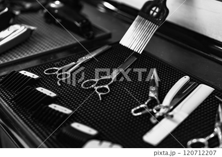 Sharp scissors and tools set on black textured surface in barbershop Sharp scissors and tools set on black textured surface in barbershop 120712207
