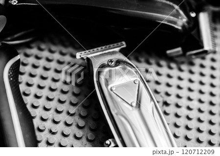 Quality hair clippers arranged on a textured surface in a barbershop setting Quality hair clippers arranged on a textured surface in a barbershop setting 120712209