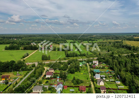 Breathtaking aerial view of lush green fields and charming houses in a serene countryside landscape Breathtaking aerial view of lush green fields and charming houses in a serene countryside landscape 120712411