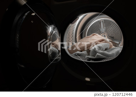View of the tumble dryer or washing machine with the door open and a towel inside View of the tumble dryer or washing machine with the door open and a towel inside 120712446