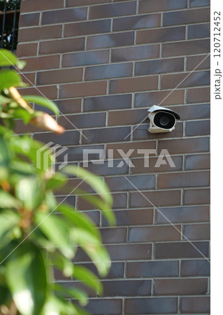 A visibly damaged security camera is mounted on a wall with its bracket still attached A visibly damaged security camera is mounted on a wall with its bracket still attached 120712452