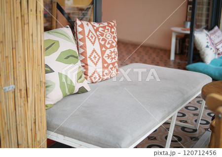 A Stylish Couch Adorned with Decorative Pillows in a Cozy and Inviting Interior Setting A Stylish Couch Adorned with Decorative Pillows in a Cozy and Inviting Interior Setting 120712456