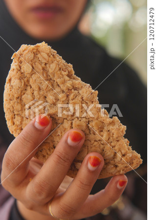 A Hand Gripping a Delicious OatBased Snack with an Inviting Biting Impression Visible 120712479