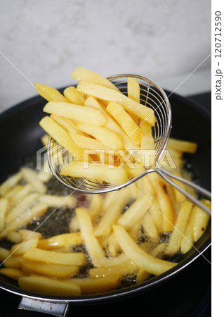 Crispy and Golden French Fries Being Deep Fried to Perfection for a Delicious Snack Crispy and Golden French Fries Being Deep Fried to Perfection for a Delicious Snack 120712590
